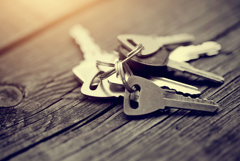 The bunch of keys lies on a wooden table.