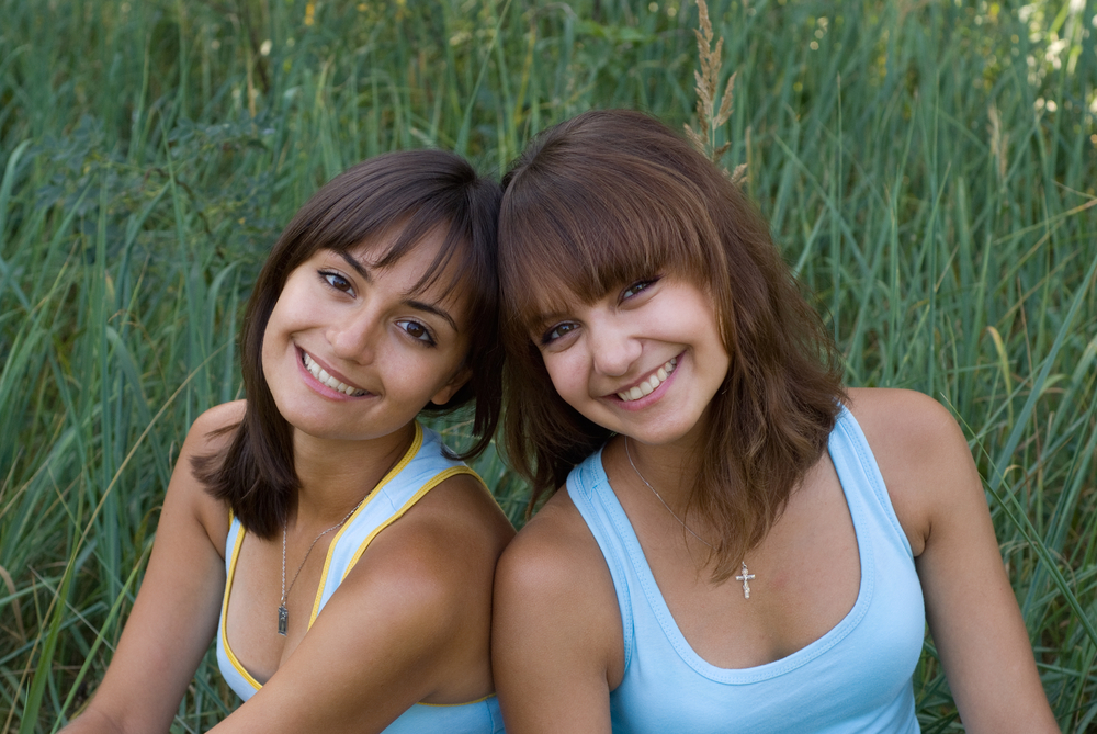 Two beautiful sisters sitting in the park
