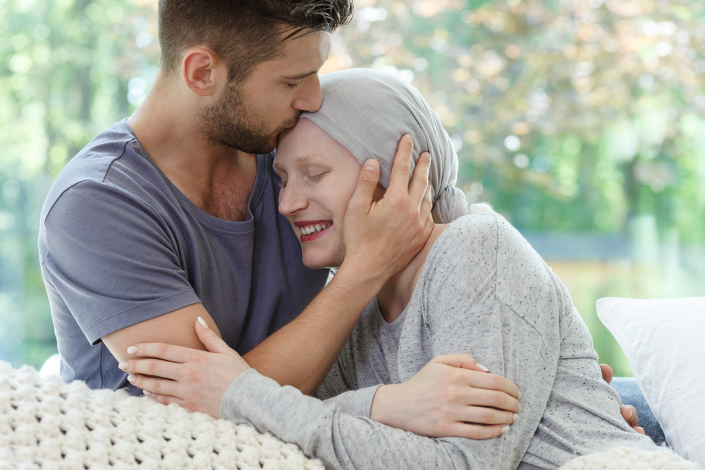 Young sick woman being kissed on the head