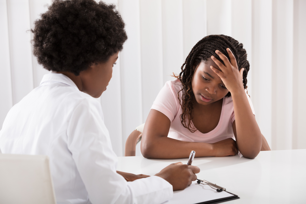 Portrait Of Female Doctor Comforting Depressed Patient
