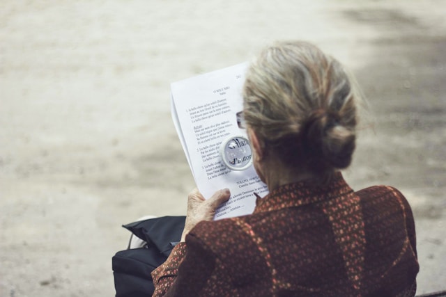 Old woman struggling to read documents