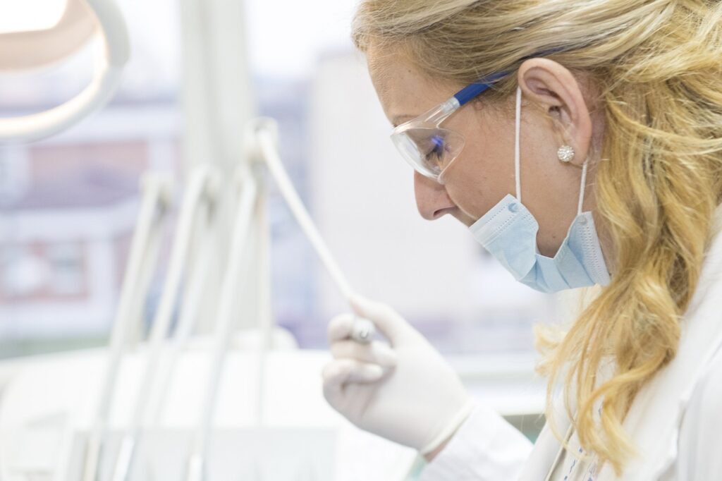 A female medical professional testing a swab. Blurred medical equipment in the background. 