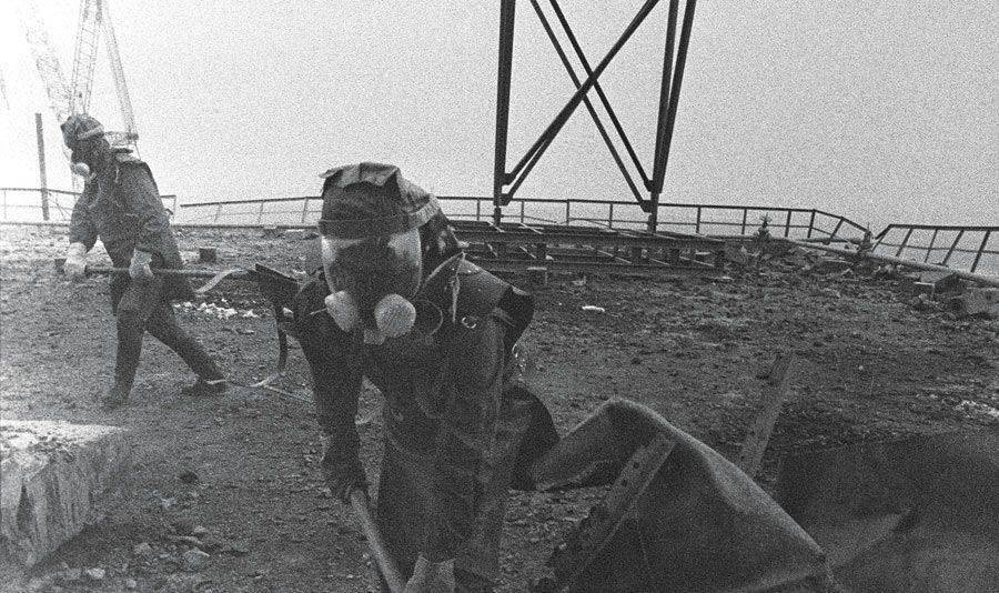 Emergency workers cleaning up radiated materials with shovels in Pripyat right after the disaster.