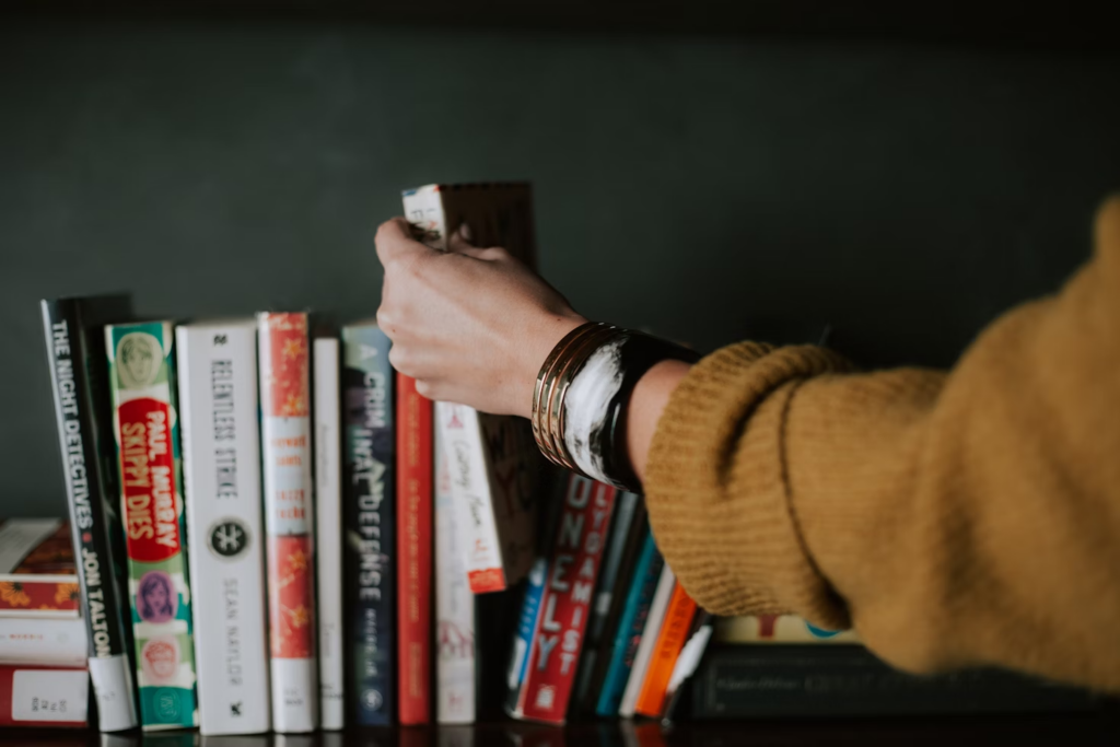 Person taking a book from a shelf