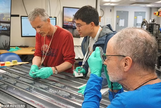 Lead researcher Johan Lissenberg from Cardiff University and two colleagues analyze the mantle rock sample. Their early findings have already been surprising.