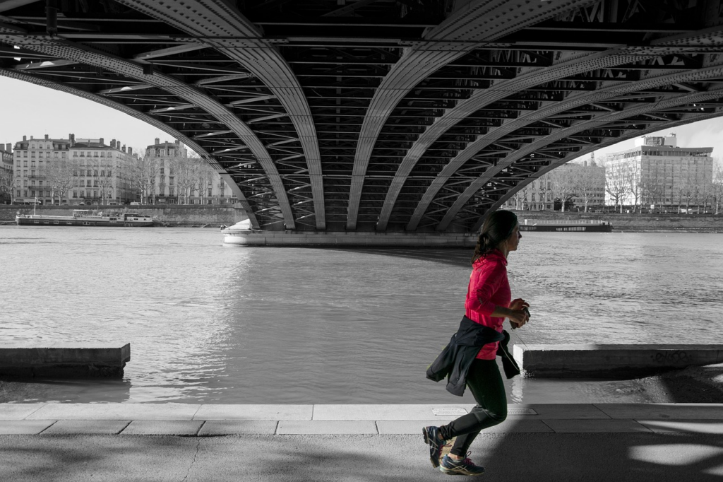 woman running under a bridge