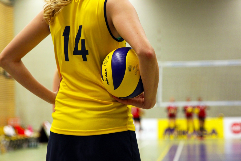 athlete holding a volleyball under her arm