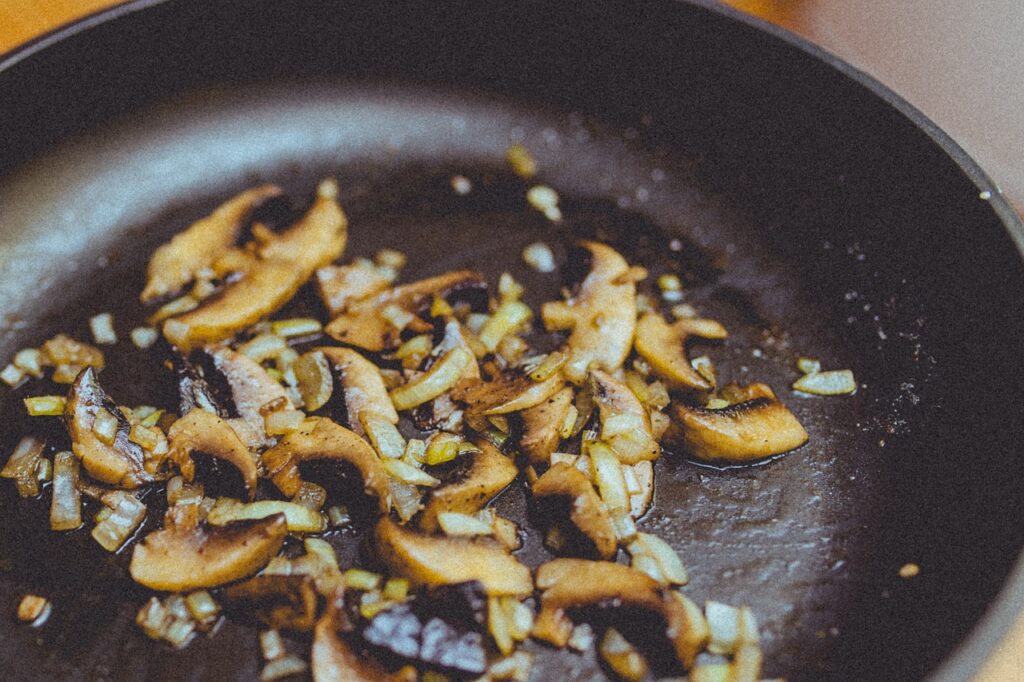 inions and mushrooms in a non-stick pan