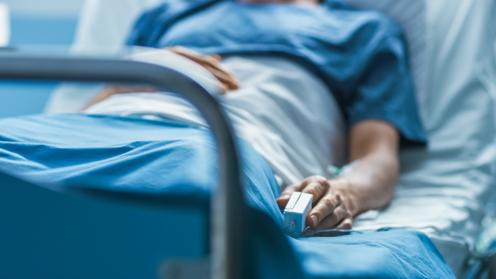 In the Hospital Sick Male Patient Sleeps on the Bed. Heart Rate Monitor Equipment is on His Finger.
