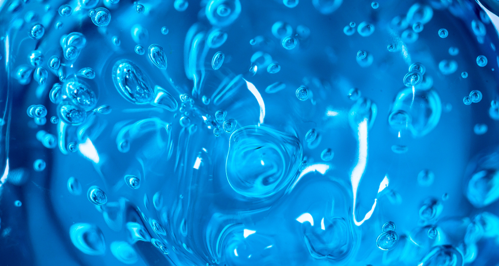 Water blue gel balls. Polymer gel. Silica gel. Balls of blue hydrogel. Crystal liquid ball with reflection. Texture background. Close up macro. Soapsuds background with air bubbles