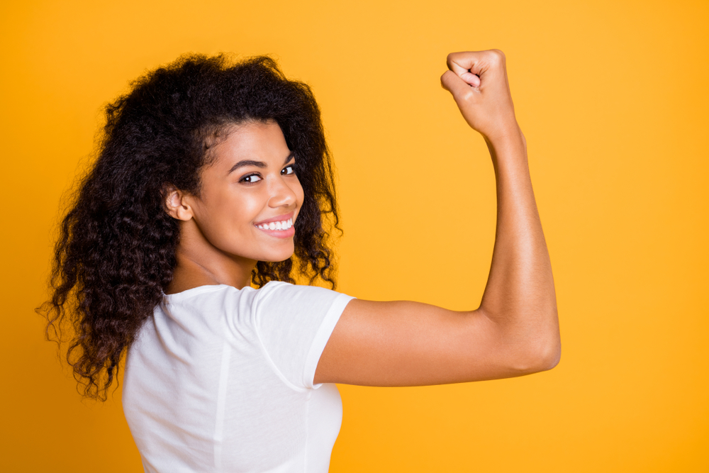 Close-up profile side view portrait of her she nice attractive lovely brunet cheerful wavy-haired girl showing strong muscles isolated over bright vivid shine vibrant yellow color background