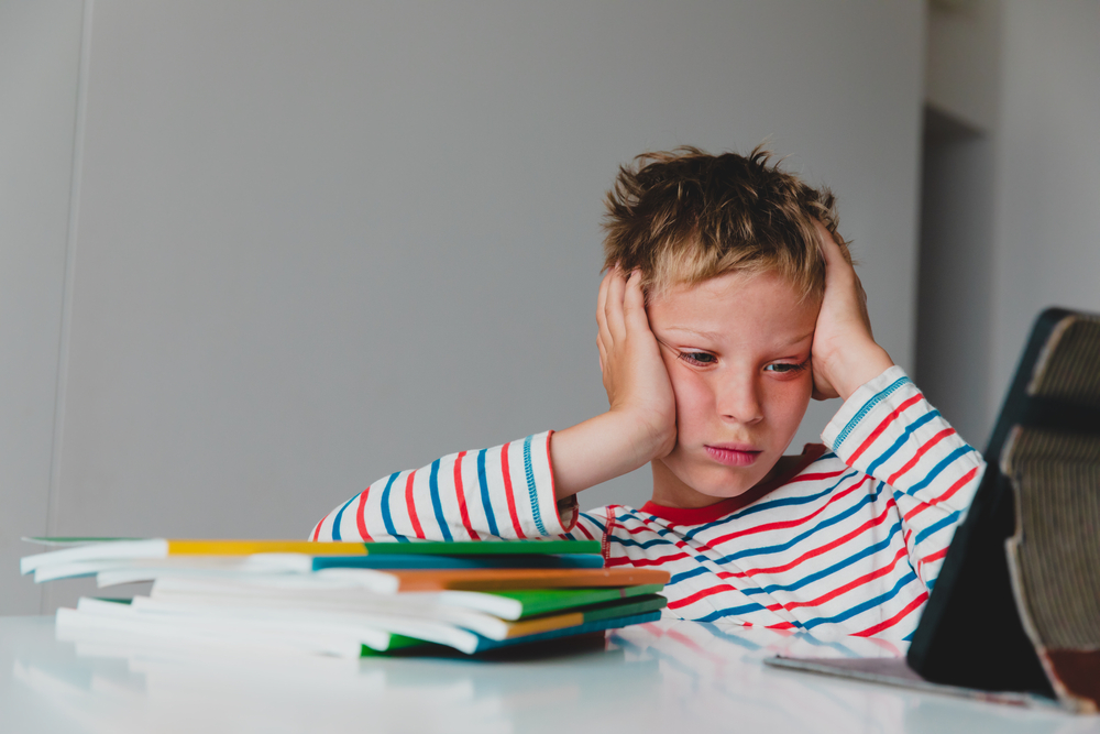 Bored and sad teenager looking at computer, kid tired of online communication and learning