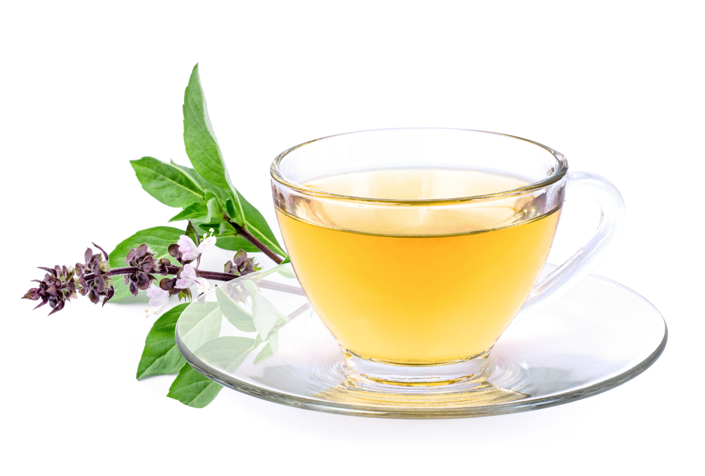 Basil tea with green basil leaf isolated on white background.
