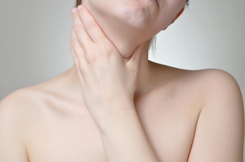 Young woman holding her painful throat
