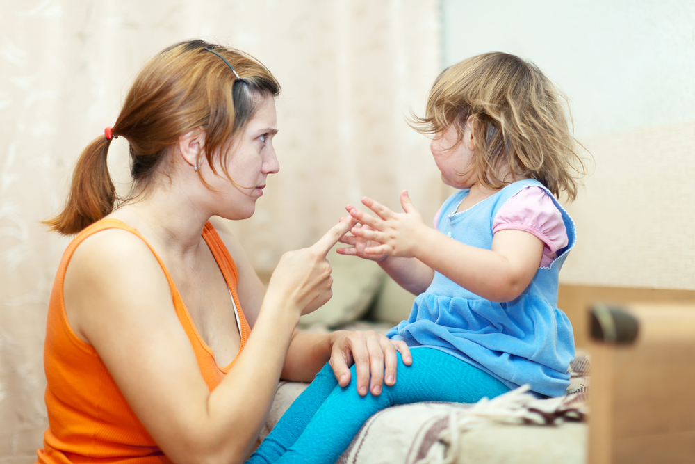 Woman scolds crying child at home interior
