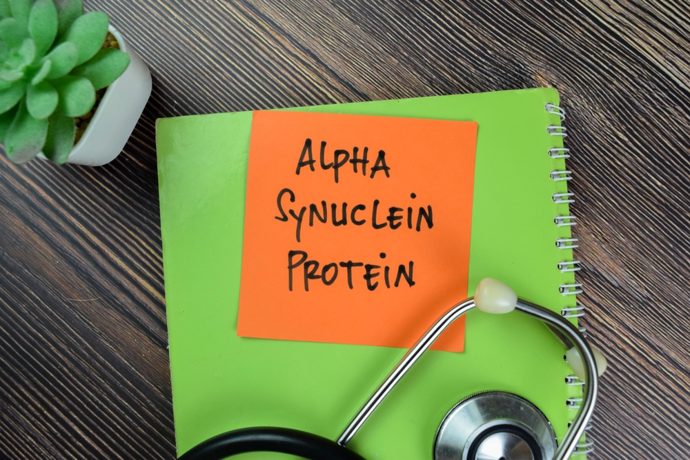 Concept of Alpha Synuclein Protein write on sticky notes isolated on Wooden Table.
