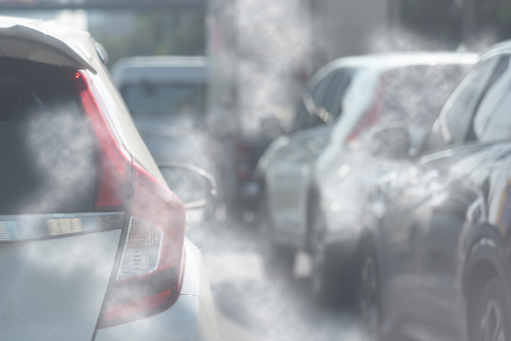 Air pollution from car exhaust smoke traffic in the city. Reducing global warming pollution and carbon dioxide from engine combustion.