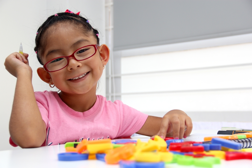 4-year-old brunette Latina girl with autism spectrum disorder ASD like Asperger, Rett and Heller draws at a desk, plays with colors alone antisocial

