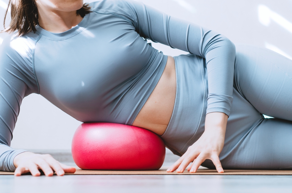 Woman doing side body obliques mindful MFR with soft ball
