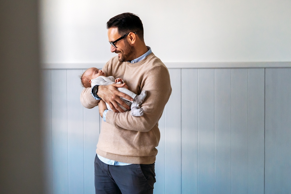 Portrait of young father holding his newborn baby. Fatherhood love single dad fathers day concept.