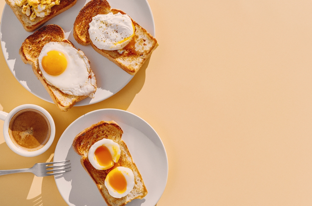 fried Toast bread with four different types of cooked chicken eggs, scrambled eggs, fried eggs, poached egg and creamed egg. Breakfast of chicken eggs.