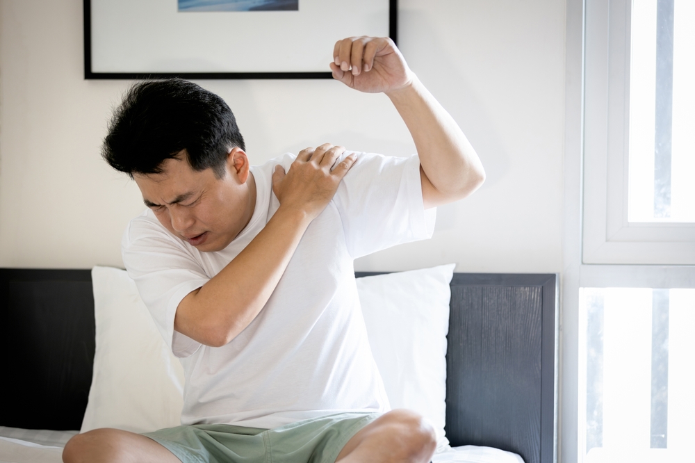 Asian middle aged man suffering from frozen shoulder,pain and stiffness,unable to move,difficulty lifting his arm,male people with calcific tendonitis or shoulder injuries,health care,medical concept
