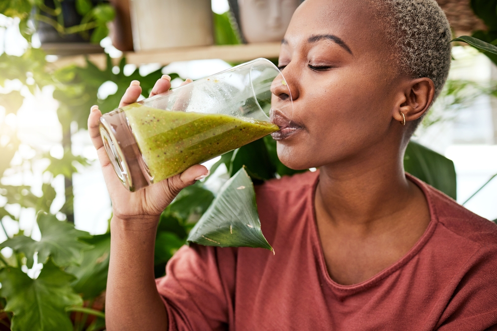 Health, drink and detox with black woman and smoothie for diet, breakfast and protein. Nutrition, food and weight loss with face of person and glass for green juice, vitamins and supplement
