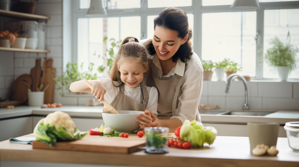 Healthy food at home. Happy family in the kitchen. Mother and child daughter are preparing proper meal.