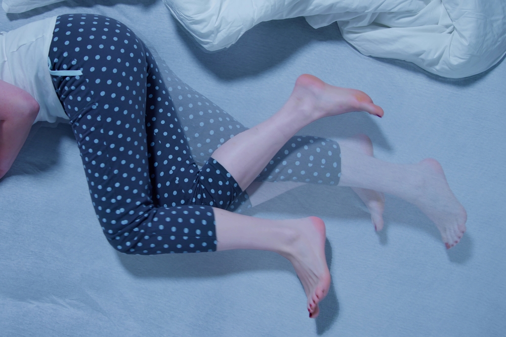 Woman With RLS - Restless Legs Syndrome. Sleeping In Bed