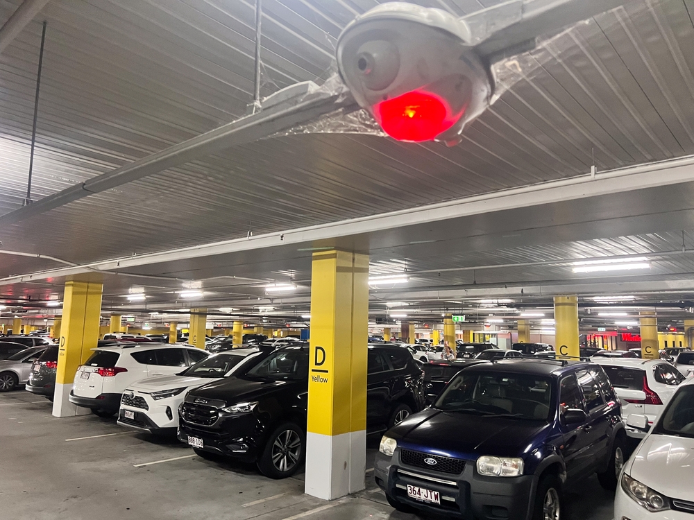BRISBANE - JAN 26 2024:Parking lot with smart sensors red light show parking space occupied.Smart Parking Sensor Technology is a radar sensor device that allows the detection of parking availability
