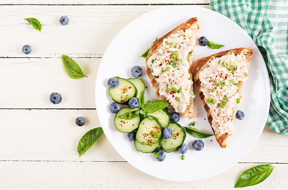 Toasts with tuna. Italian toasts sandwiches with pate canned tuna, egg and cucumber. Top view, flat lay,