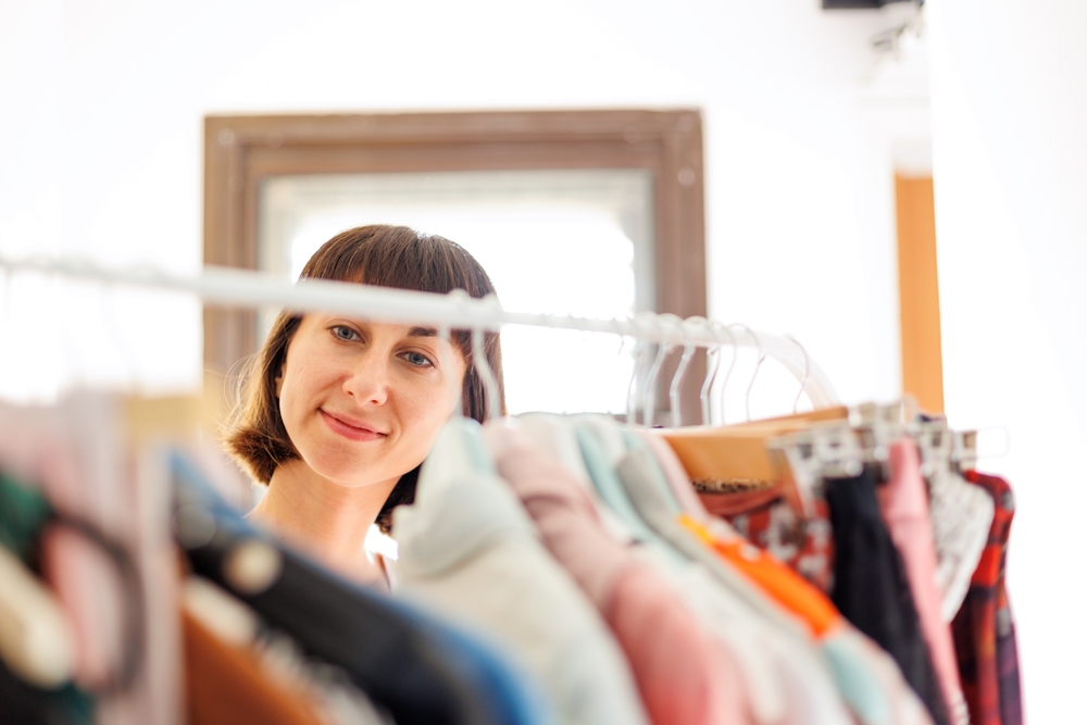 Home wardrobe or dressing room of a clothing store. a young woman chooses a fashionable outfit in her closet at home or in a store. The girl thinks about what to wear.
