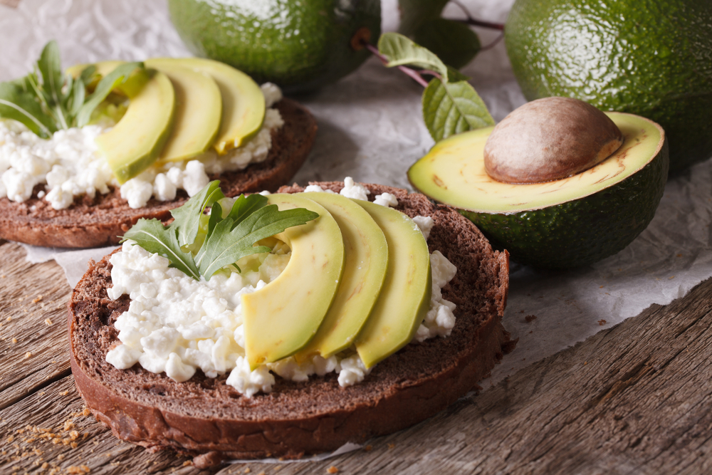 Simple sandwiches with avocado, cottage cheese and arugula close-up on the table. horizontal
