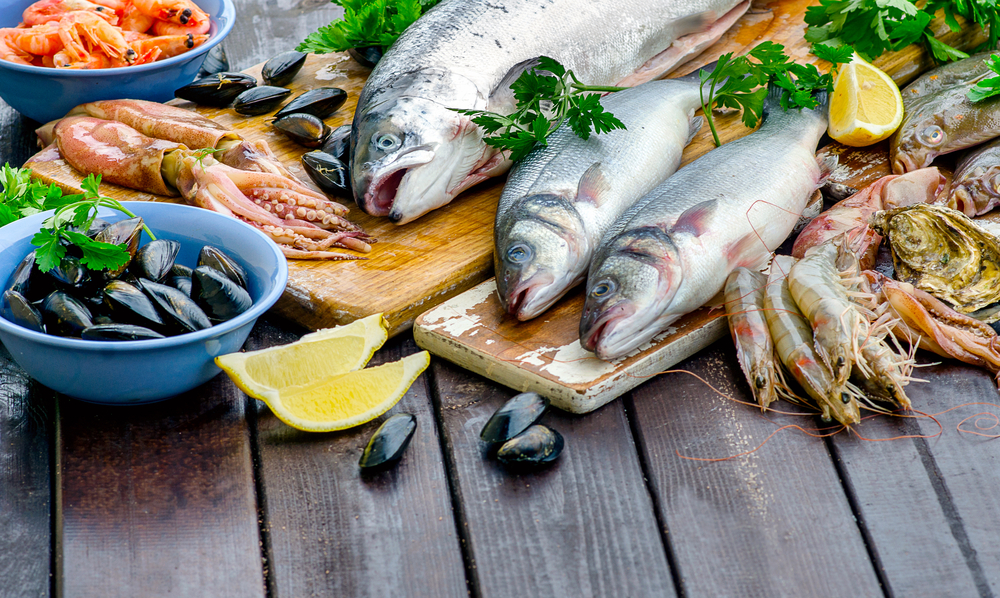 Raw seafood on wooden board. Healthy eating. View from above