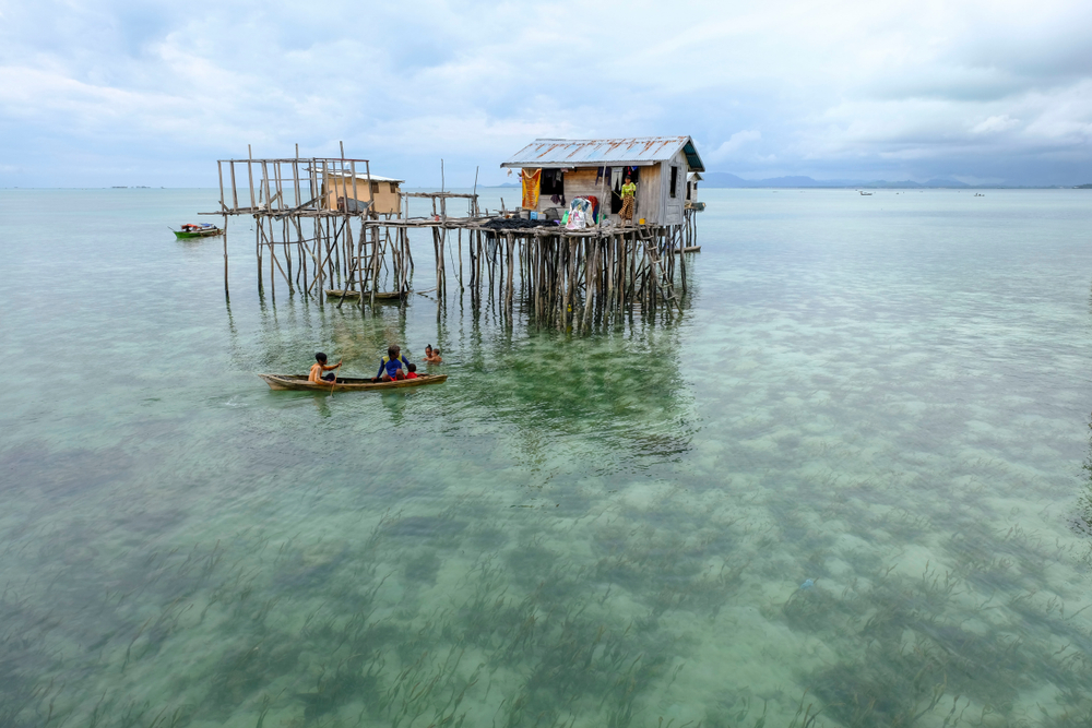 Sabah, Malaysia-Dec 18, 2017:Daily life of unidentified Borneo Sea Gypsy kids on a canoes in Omadal Island, Malaysia. They living on long boats known as lepa and stilt house in the middle of ocean.