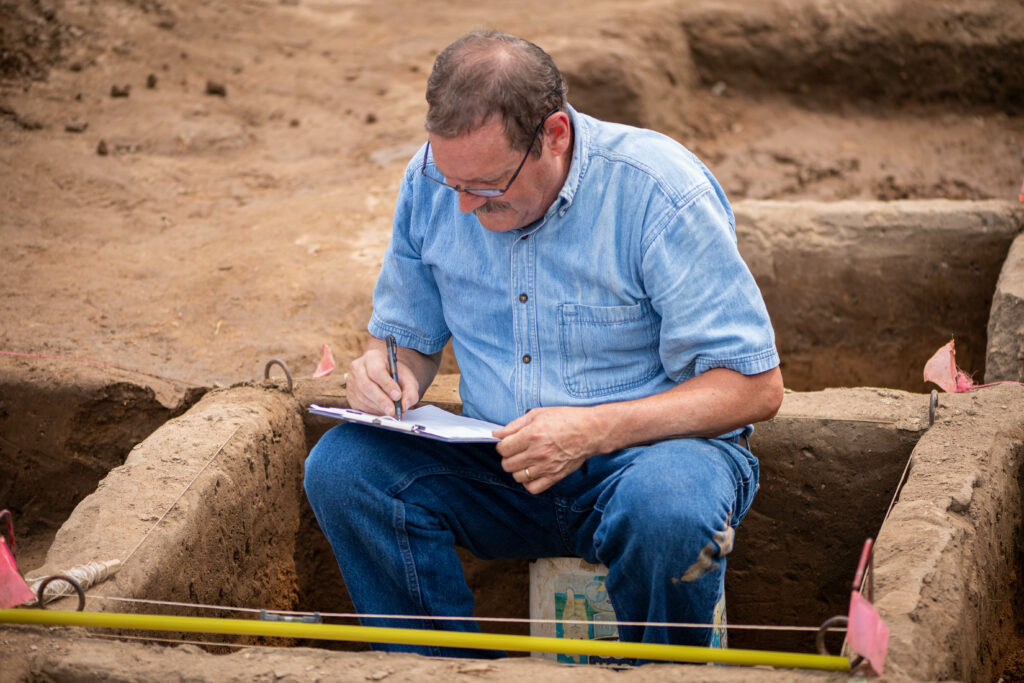 Professor taking notes on the campsite measurements