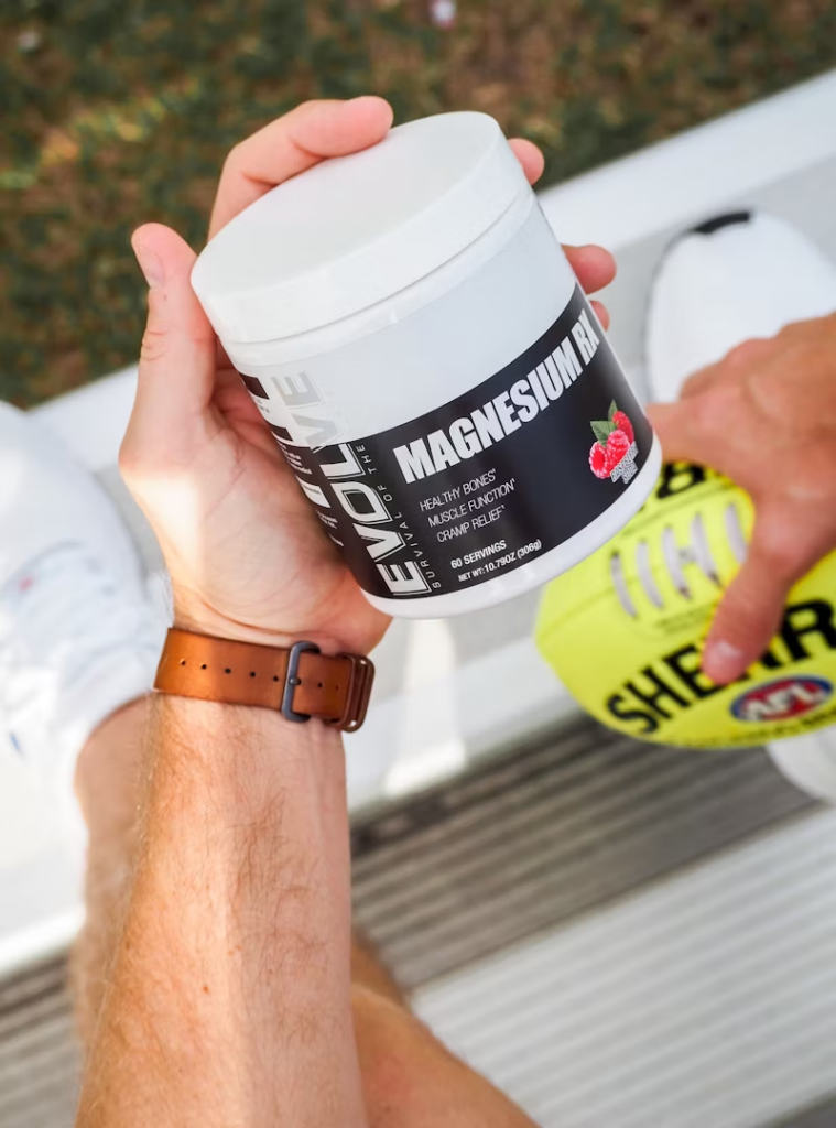 man holding a container of magnesium supplementss