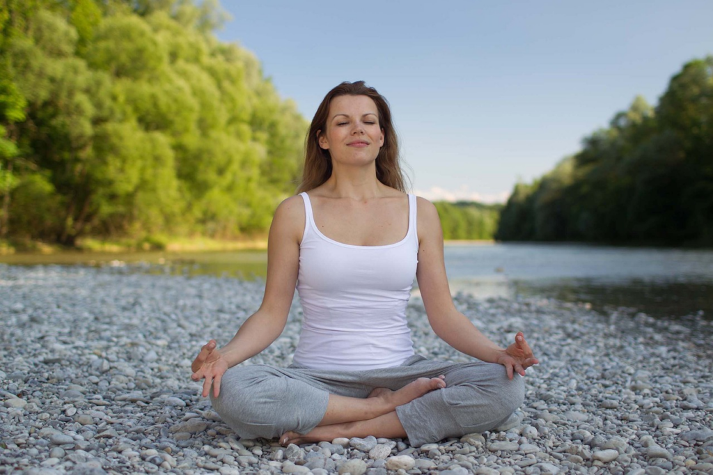 woman cross legged meditation on rocks