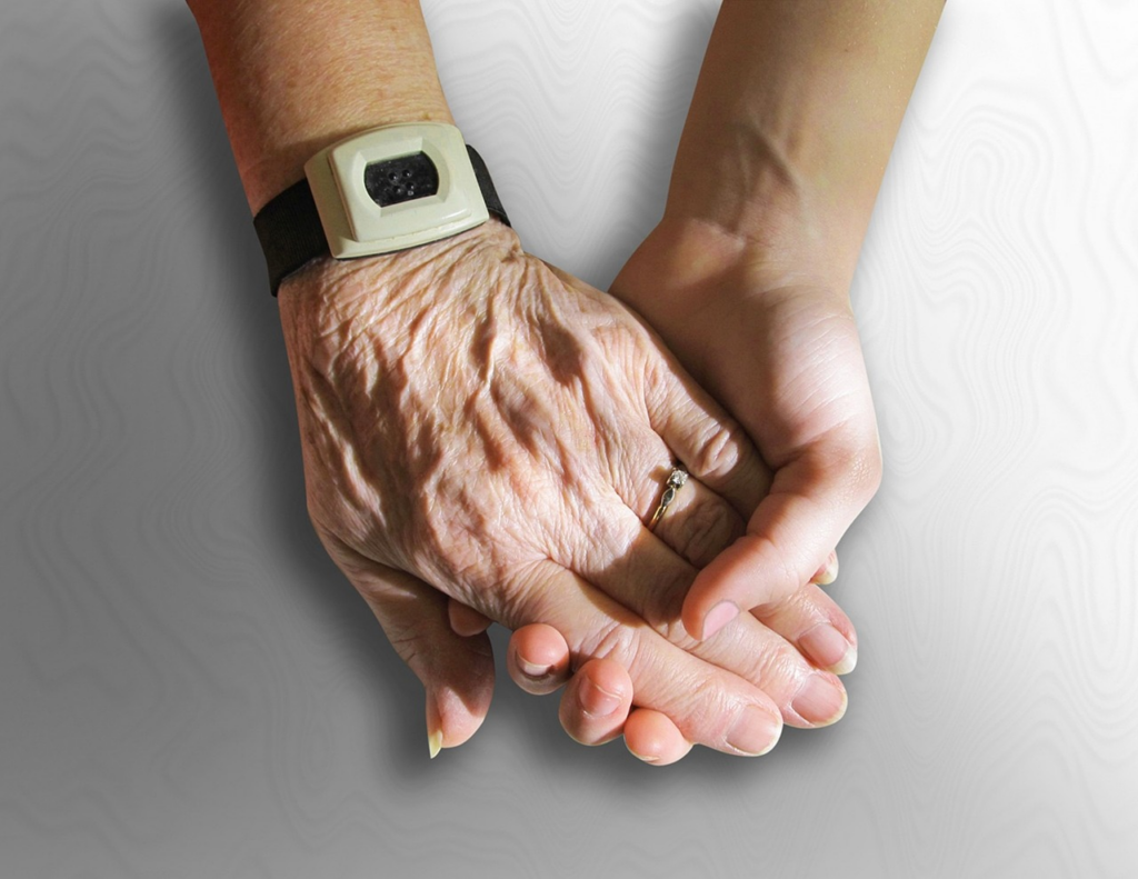 an older and younger hand holding each other