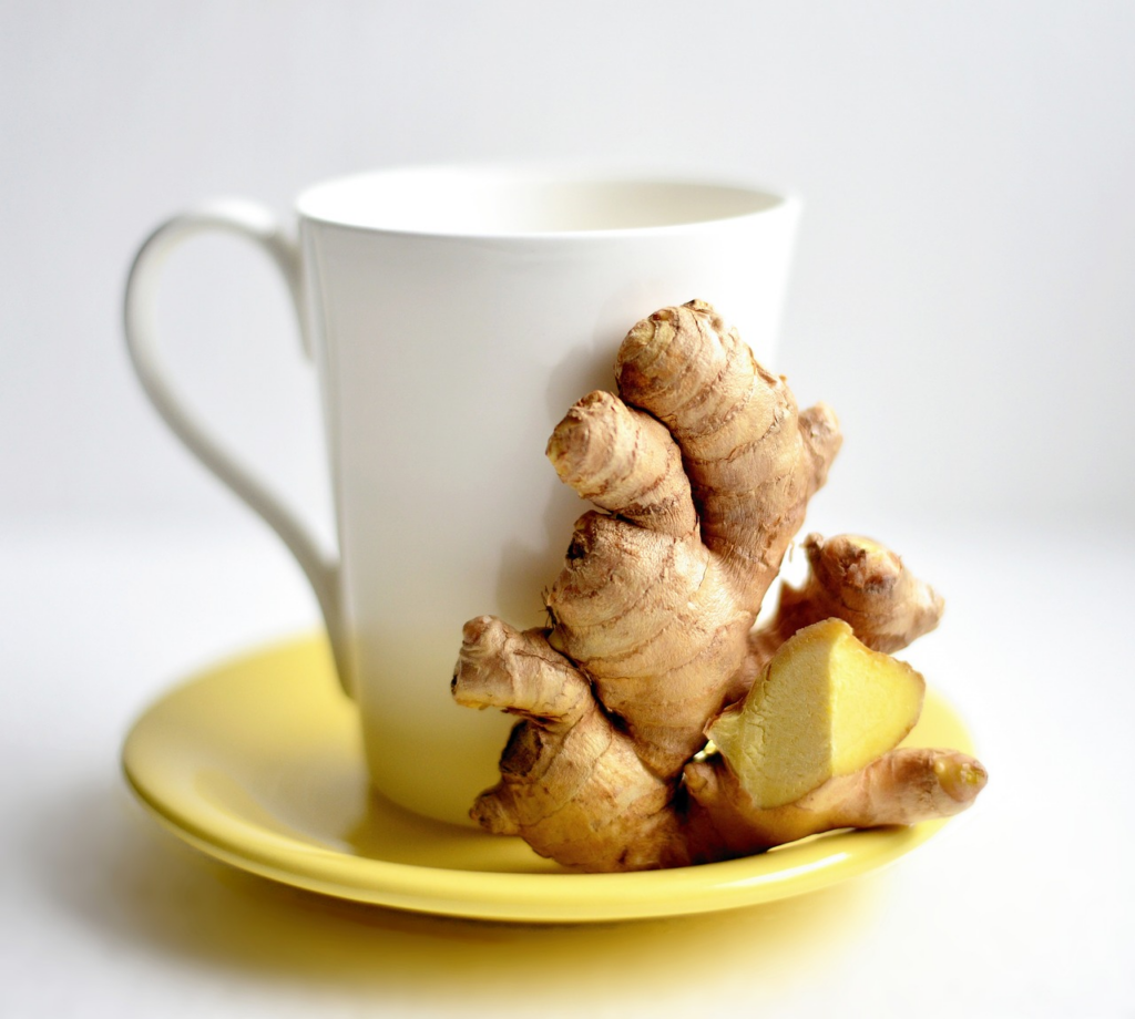 a mug on a saucer with ginger beside it
