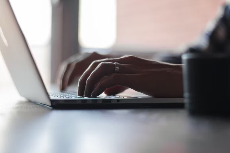 person typing on their computer