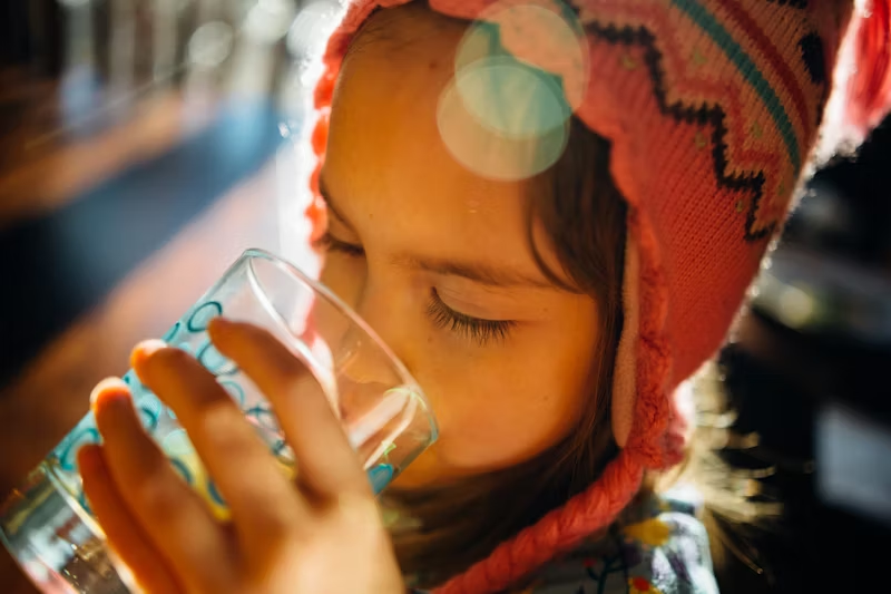 child drinking water from a glass