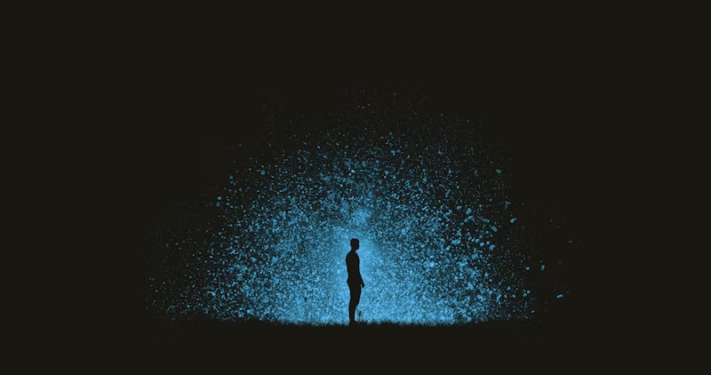 person standing in front of bright blue explosion