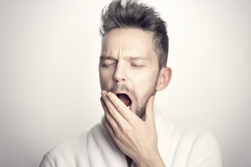 person yawning into their hand