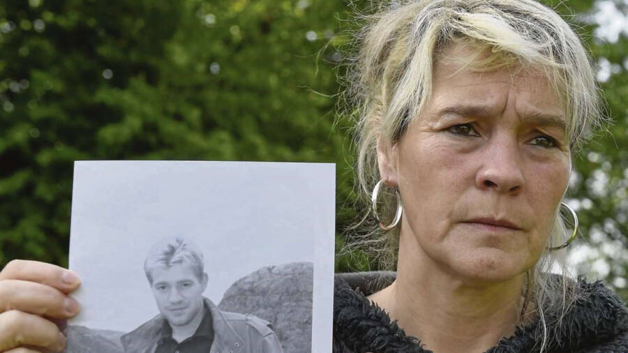 Lars Mittank’s mother holding a missing poster of her son.