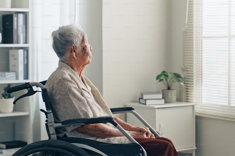 older gentleman in a wheelchair looking out the window