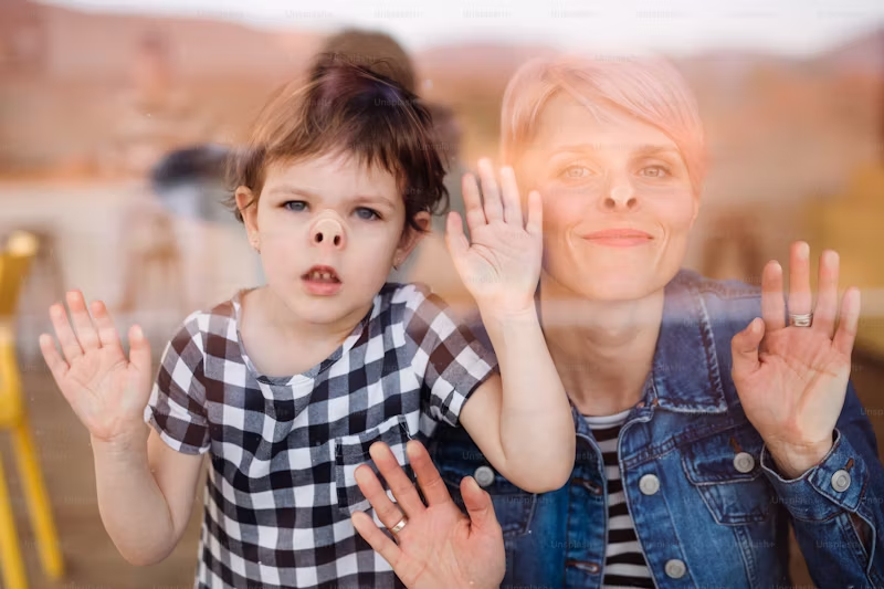 mom and child with noses pressed into glass