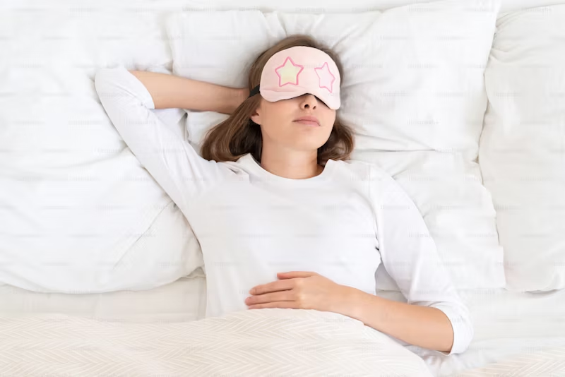 woman with sleep mask with stars on it in bed