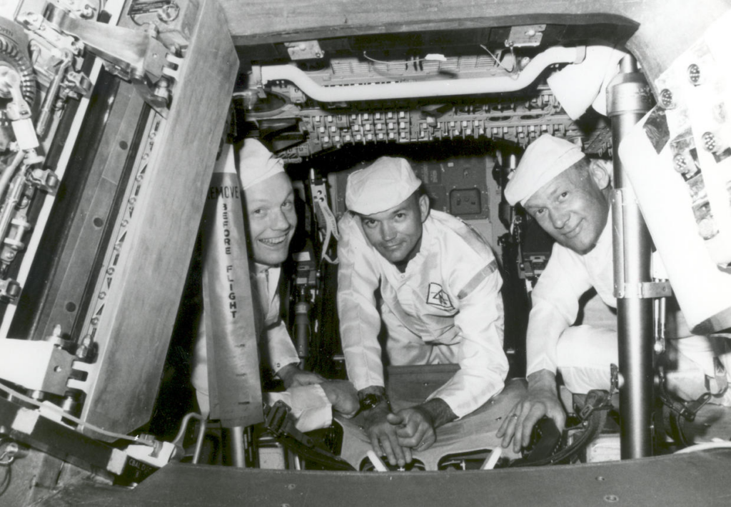 The Apollo 11 crew, from left: from left, Neil Armstrong, commander; Michael Collins, command module pilot; and Buzz Aldrin, lunar module pilot, conducting a crew compartment fit and functional check, of the equipment and storage locations, in their command module.