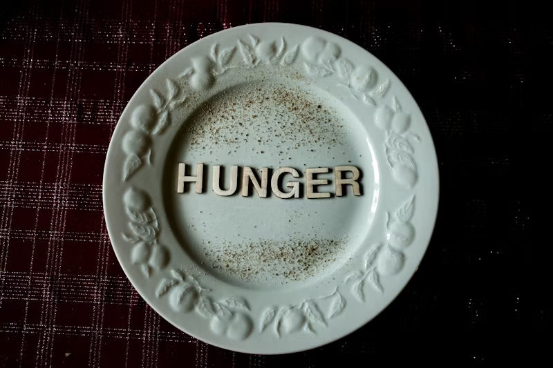 AN empty plate with letter spelling HUNGER on it